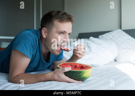 Kaukasische mann Wassermelone zu Hause essen Stockfoto