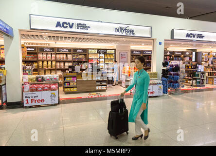 Eine Stewardess zu Fuß hinter dem Duty Free Shop, Flughafen Ho Chi Minh Tan Son Nhat International Airport), Vietnam, Asien Stockfoto