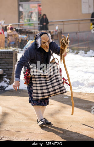 PERNIK, Bulgarien - 26. JANUAR 2018: Junger Mann verkleidet als Hexe, scary Maske und Holzstab vertreibt böse Geister bei der jährlichen Internationalen Fest Stockfoto