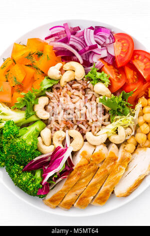 Buddha Schüssel Schüssel mit hühnerfilet, brauner Reis, Pfeffer, Tomaten, Brokkoli, Zwiebel, Kichererbse, frischen Salat Salat, Cashew und Walnüsse. Gesunde, ausgewogene Stockfoto