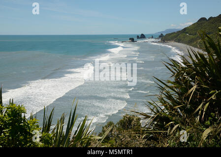 Native Bush Frames ein Strand bei Ebbe auf dem West Coast Beach, South Island, Neuseeland Stockfoto