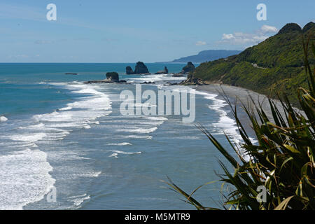 Native Bush Frames ein Strand bei Ebbe auf dem West Coast Beach, South Island, Neuseeland Stockfoto