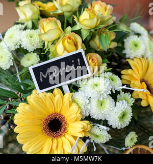 Blumenstrauß aus gelben und weißen Rosen, Gerberas, Chrysanthmen und kleinem Kelch mit französischem Text: Vielen Dank Stockfoto