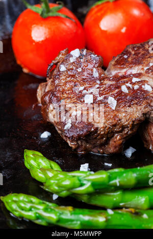 Rindersteak und grünem Spargel in einem Topf Stockfoto