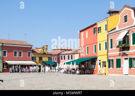 Touristen einkaufen bei bunten Geschäften auf der Piazza Baldassarre Galuppi, Burano, Venedig, Venetien, Italien Stockfoto