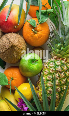 Verschiedene Tropische und Sommer Früchte. Ananas Mango Coconut Citrus Orangen Zitronen Äpfel, Kiwi, Bananen auf Marmor Stein Hintergrund. Gesund Stockfoto