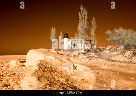 Die Außenseite des historischen Point Betsie Lighthouse auf Sandy Lake Michigan Strand im Winter im Infrarot. Stockfoto