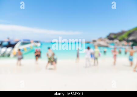 Blurry abstrakt Hintergrund der Touristen zu Fuß am Strand und Meer mit Berg an sonnigen Tag, Sommerurlaub Konzept. Stockfoto