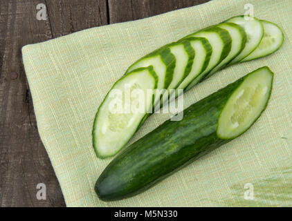 Frischen Gurkenscheiben auf dem dunklen Hintergrund und Tuch. Stockfoto