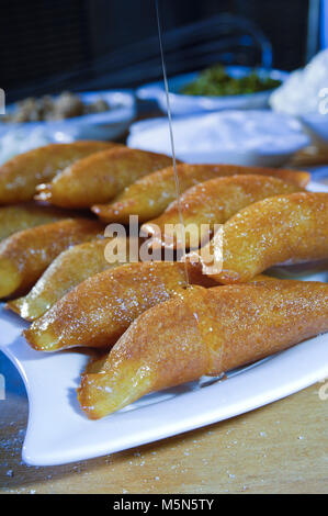 Gießen Sirup auf Qatayef, arabische Süßigkeiten mit Muttern und andere Zutaten für Ramadan und Eid Stockfoto