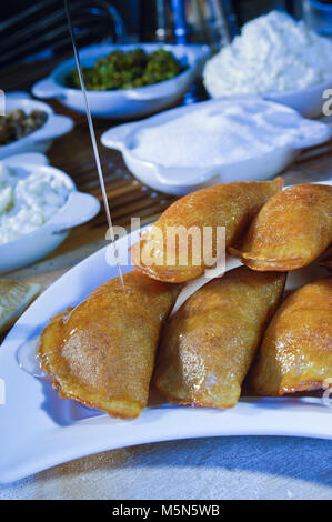 Gießen Sirup auf Qatayef, arabische Süßigkeiten mit Muttern und andere Zutaten für Ramadan und Eid Stockfoto