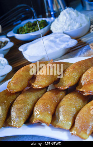 Gießen Sirup auf Qatayef, arabische Süßigkeiten mit Muttern und andere Zutaten für Ramadan und Eid Stockfoto