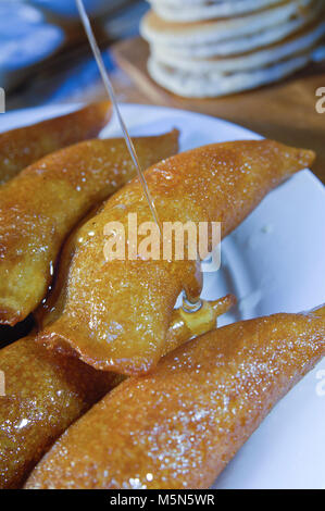 Gießen Sirup auf Qatayef, arabische Süßigkeiten mit Muttern und andere Zutaten für Ramadan und Eid Stockfoto