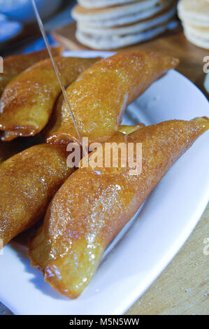 Gießen Sirup auf Qatayef, arabische Süßigkeiten mit Muttern und andere Zutaten für Ramadan und Eid Stockfoto