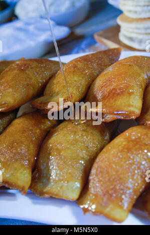 Gießen Sirup auf Qatayef, arabische Süßigkeiten mit Muttern und andere Zutaten für Ramadan und Eid Stockfoto