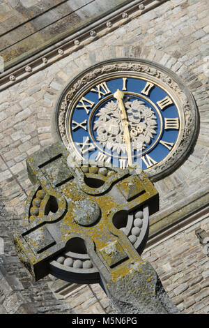 Ein keltisches Kreuz religiöses Symbol und einer alten oder historischen Kirche Wecker in einem Winkel. Die Zeit von einem großen Zifferblatt auf eine Kirche oder eine Kapelle. Stockfoto