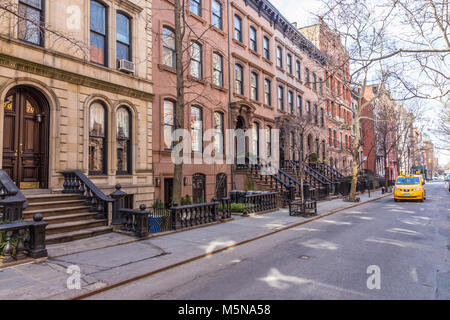Malerische, von Bäumen gesäumten Straße der historischen Sandsteinhaus Gebäude im Stadtteil West Village von Manhattan in New York City NYC USA Stockfoto