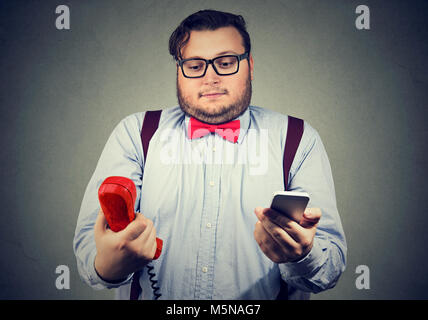 Junger Mann in formalen Outfit suchen verwundert über altmodische und zeitgenössische Gadgets. Stockfoto