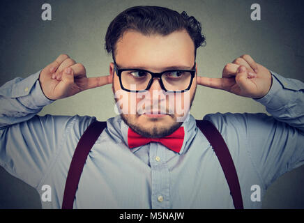 Junge hartnäckige Menschen verhalten kindisch und stoppen Ohren suchen beleidigt. Stockfoto