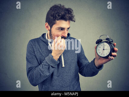 Junge casual Mann mit Uhr und Suchen betonte mit Verspätung. Stockfoto