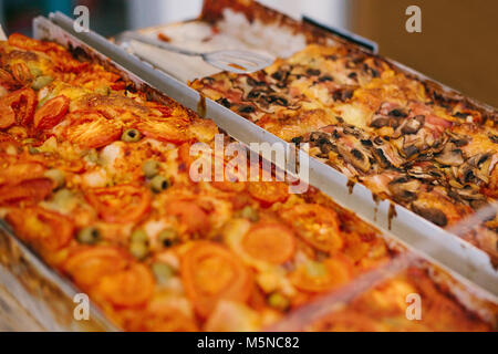 Eine köstliche gebackene Pizza mit Käse, Tomaten, Pilze und Oliven, in der Bäckerei verkauft. Stockfoto