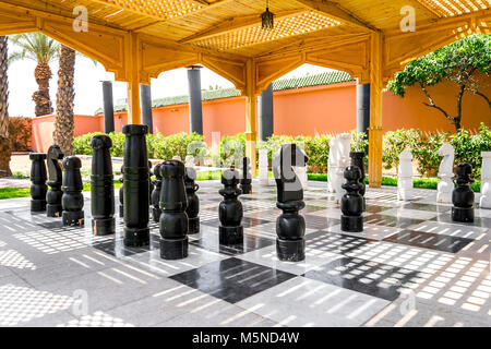 Riesige Schachfiguren, die von einem Garten umgeben Stockfoto