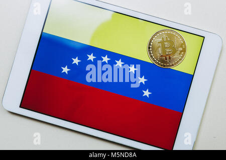 Nahaufnahme einer Tablette mit der Flagge Venezuelas und ein bitcoin Gold auf es Stockfoto