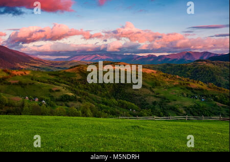 Schönen ländlichen Gegend in den Bergen. wunderschöne Landschaft mit schönen Wolkenformationen über den Bergrücken in rotes Licht bei Sonnenuntergang Stockfoto