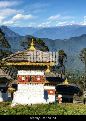 Punakha, Bhutan. Chörten (Schreine) bei einem Pass in den Ausläufern des Himalaja, Himalaya Berge in der Ferne. Stockfoto