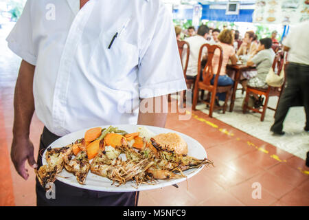 Cancun Mexico, Mexican, Mercado 28, El Cejas, Restaurant im Inneren oder hispanischer Mann, Kellner, der Server Seafood Teller gegrillte Garnelen serviert Stockfoto