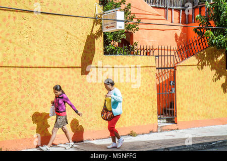 Cancun Mexiko, Mexiko, Yucatán-Halbinsel, Quintana Roo, lateinamerikanische lateinamerikanische Einwanderer Minderheit, Straße, Bürgersteig, gelbe Mauer, Tor, Erwachsener Stockfoto