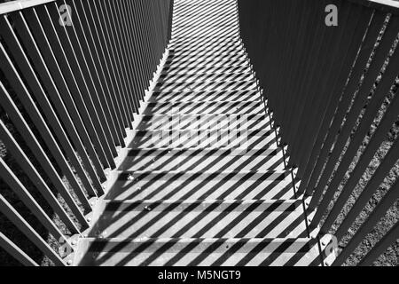 Geometrische Schatten - Linien und parallelen Streifen auf Treppen. Sonne und Schatten spielt. Grafik- und kontrastreiches Bild. Stockfoto