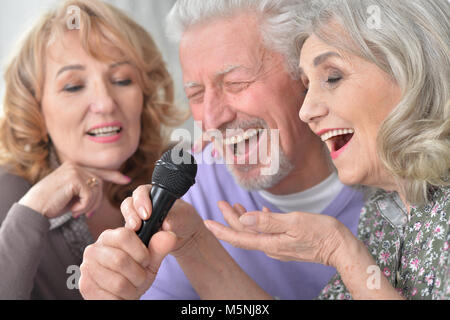 Ältere Leute Karaoke singen mit Laptop, während Tee trinken. Stockfoto