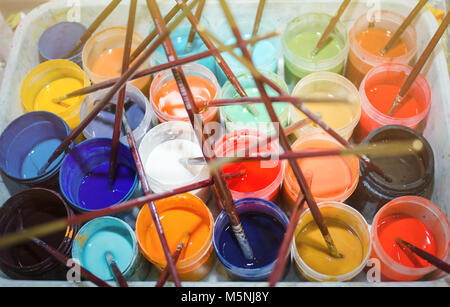 Viele farbige öffnen Dosen mit Farbe und Pinsel, Ansicht von oben. Stockfoto
