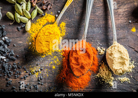 Bunte Gewürze auf dem alten Board Stockfoto