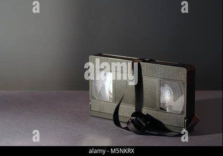 Alte schwarze Videokassette mit Klebeband auf dunklem Hintergrund Stockfoto