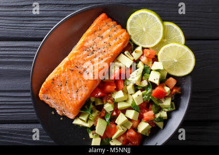 Würzige gebackenen Lachs Steaks und frischem Gemüse Salat close-up auf einem Teller. horizontal oben Ansicht von oben Stockfoto