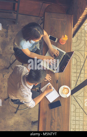 Blick von oben auf die zwei Mitarbeiter arbeiten am Laptop Stockfoto