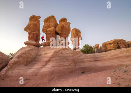 Wanderer zwischen hoodoos Sandstein Felsformationen bei Sonnenuntergang in Devil's Garden, Grand Staircase-Escalante National Monument, Utah USA Stockfoto