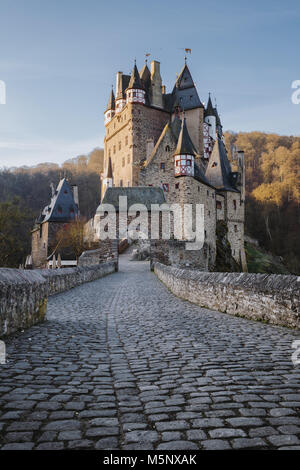 Schönen Blick auf die berühmte Burg Eltz im malerischen golden Morgen bei Sonnenaufgang mit blauem Himmel an einem sonnigen Tag im Herbst mit Retro Vintage Frage neue Stil filt Stockfoto