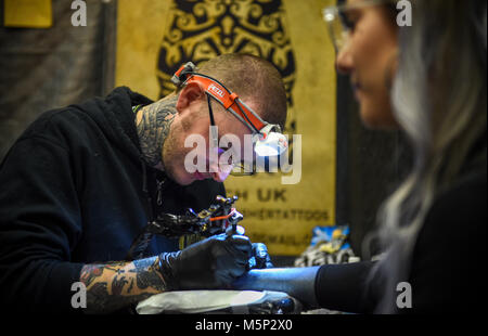 Brighton UK 25. Februar 2018 - Tattooists bei der Arbeit auf der 11. jährlichen Brighton Tattoo Convention statt in der Brighton Centre am Wochenende zieht Tattoo Künstler aus aller Welt: Simon Dack/Alamy leben Nachrichten Stockfoto