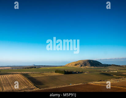 Blaikie Heugh East Lothian, Schottland, Vereinigtes Königreich, 25. Februar 2018. Völlig klaren blauen Himmel mit geringer Sonneneinstrahlung von der untergehenden Sonne glänzt auf Berwick Traprain Recht und Gesetz, Reste der vulkanischen Stecker und lokale Wahrzeichen Funktionen Stockfoto