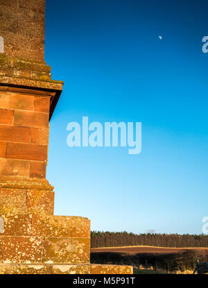 Blaikie Heugh East Lothian, Schottland, Vereinigtes Königreich, 25. Februar 2018. Völlig klaren blauen Himmel mit geringer Sonneneinstrahlung von der untergehenden Sonne leuchtet auf dem Hügel obelisk Balfour Monument, einem Denkmal für James Maitland Balfour, die Konservative in den 1840er Jahren, und der Vater von Premierminister Arthur Balfour, 1 Graf von Balfour. Der zunehmende Mond ist sichtbar in den strahlend blauen Himmel Stockfoto