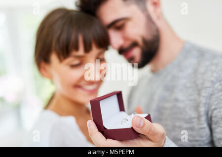 Junger Mann mit Hochzeit Ringe in einer Box macht eine Frau zu Frau Stockfoto