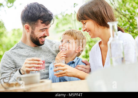 Vater und Sohn sind Zusammen Spass haben und Mutter ist sie zu beobachten im Garten Stockfoto