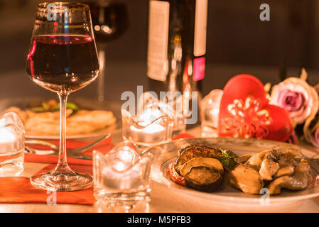 Romantisches Abendessen für Zwei mit Wein, Kerzen, Blumen Stockfoto