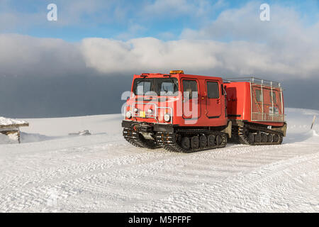 Red ratrak Snowcat im Winter bergen ein roter Schnee tucker mit dem Schnee im Riesengebirge Berg bedeckt. Rot über - Schnee Fahrzeug, Stockfoto