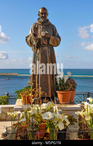 Bronzestatue des heiligen Pio im Hafen von Castellammare del Golfo, Sizilien, Italien. Stockfoto