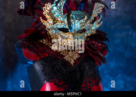 In venezianischem Rot, Maske und roten Korsett mit Stücken von Gold und schwarze Spitze Stoffen auf Metall Schild. Handgefertigte piea für Partys oder Kostüm Sitzungen Stockfoto