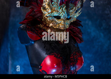 Maskerade Partei in venezianischem Rot, Maske und roten Korsett mit Stücken von Gold und schwarze Spitze Stoffen auf Metall Schild. Handgefertigte piea für Partys oder costu Stockfoto